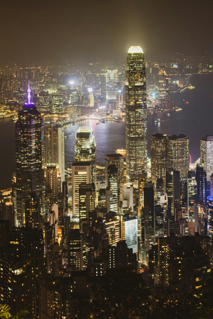 Stunning nighttime view of Hong Kong's illuminated skyline from Victoria Peak with iconic skyscrapers.